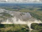 Aerial view of Victoria Falls, where mist and sunlight still form rainbows