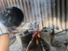 My host sister starting the cooking fire in the dapur (kitchen)