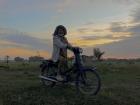 My aunt on her moto working in her rice field 