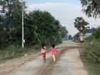 Two students skipping down the road 
