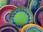 Plates painted in bright colors for sale at Swazi Candles.