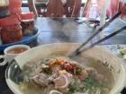 A steaming hot bowl of a Cambodian soup called "Kuy Teuv"
