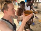 Elisha drinking a local beverage out of a calabash