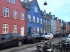 Danish street with colorful houses and a bike rack in the corner 