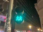 A green pedestrian crosswalk signal with two people on it
