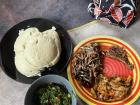 Nshima served with kapenta (small fried fish), a rib of goat, eggplant and kale