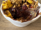 Açaí bowl with mango, strawberries, granola, and peanut butter