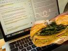Finishing up some homework while having a turkey, pesto and arugula bagel