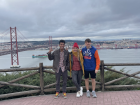 My classmates and I posing near the Tagus River with the 25 de Abril Bridge in the background.