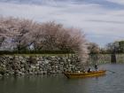 A shot of a couple of Japanese men going down the river outside of Himeji Castle
