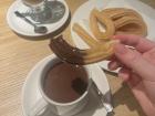 Dip the churros in the melted chocolate to enjoy this delicious Spanish sweet treat!