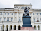 A seated bronze statue of Nicolaus Copernicus, a famous Polish astronomer, in front of the historic Staszic Palace, home of the Polish Academy of Sciences 