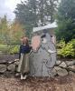 Stella standing in front of a cartoon elephant cut out at the zoo, holding up a peace sign. The photo is taken outside and the weather is gloomy. 